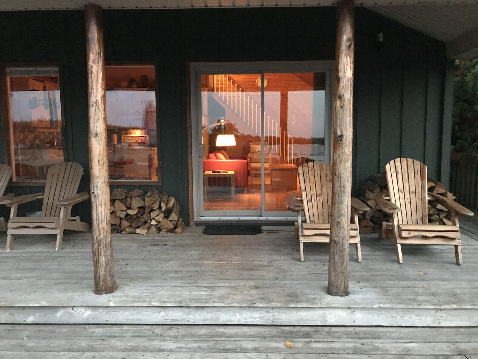 Covered porch with Muskoka chairs at sunset