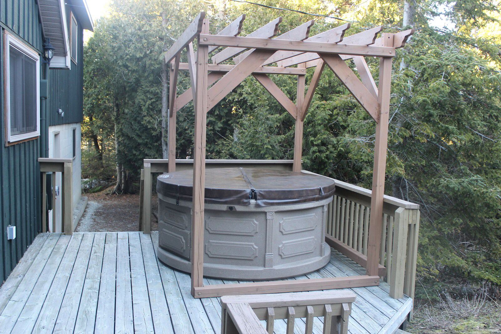 Hot tub under a pergola on the deck